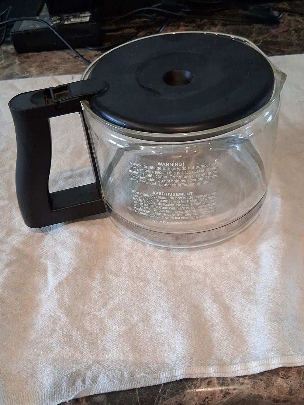 Bunn 10-cup replacement‎ glass carafe featuring a black lid and handle.